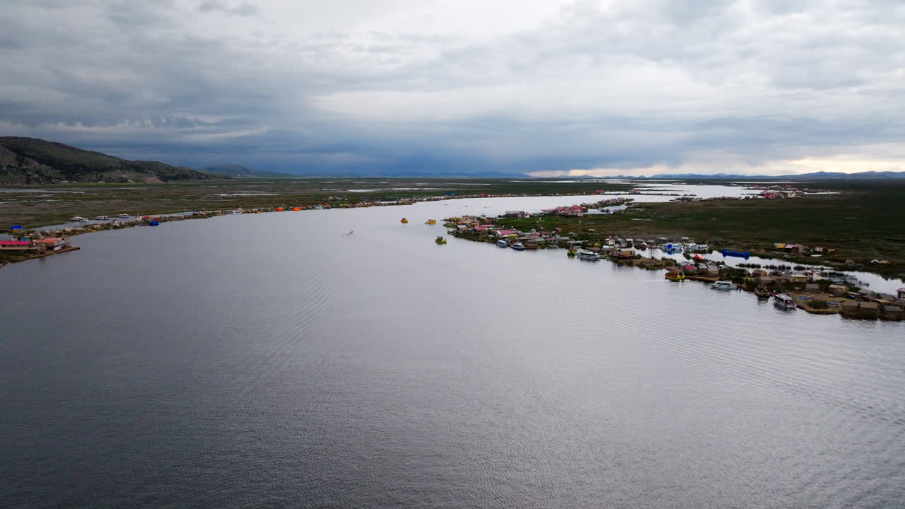 Uros floating islands on Lake Titicaca, for travel, cultural, or environmental content. Puno, Peru. Aerial forward, copy space