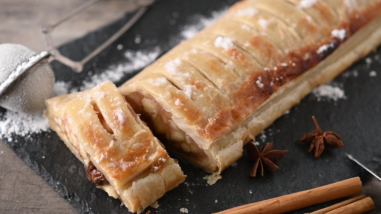 Tagliare strudel di mele fatto in casa su un tavolo rustico