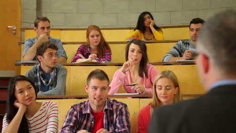 student raising her hand to ask question in lecture