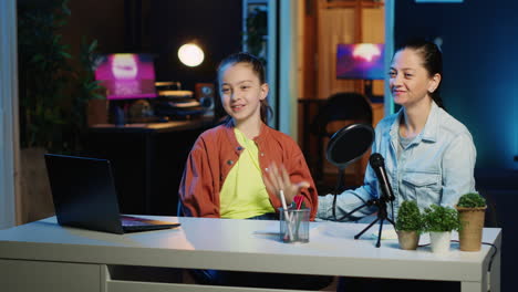 niña joven y su madre usando dispositivos de grabación para filmar la introducción para el canal de vlog familiar