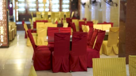 an amazing shot of the dining area at a classic asian wedding, decorated in a stunning red and golden theme