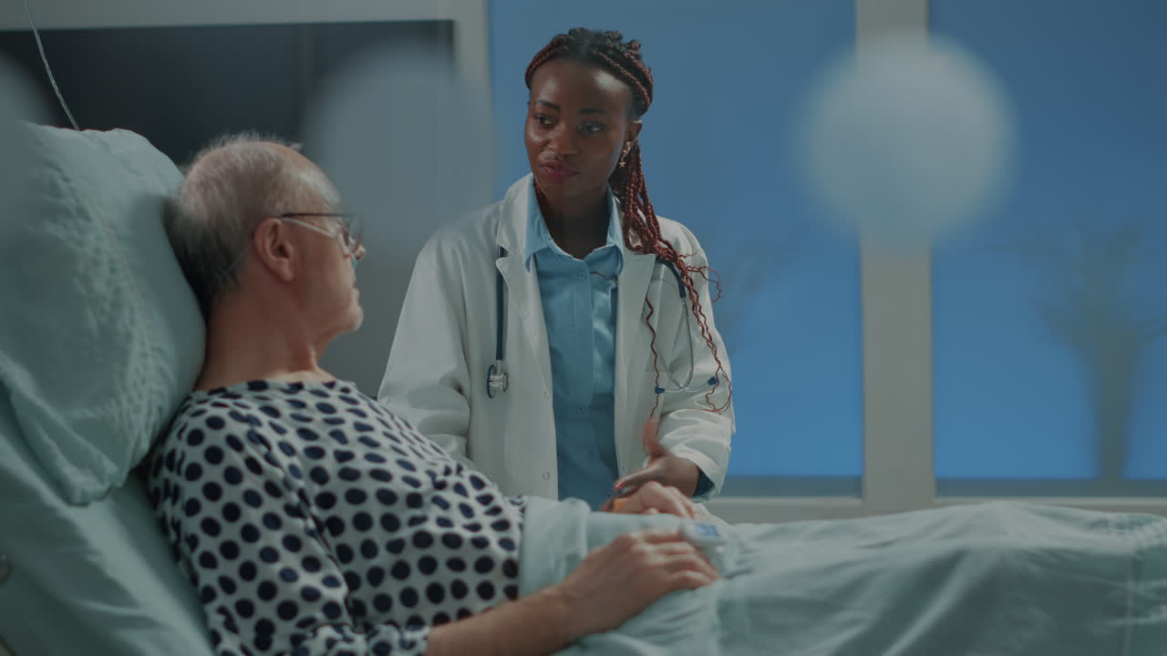 African american doctor talking to elder sick patient