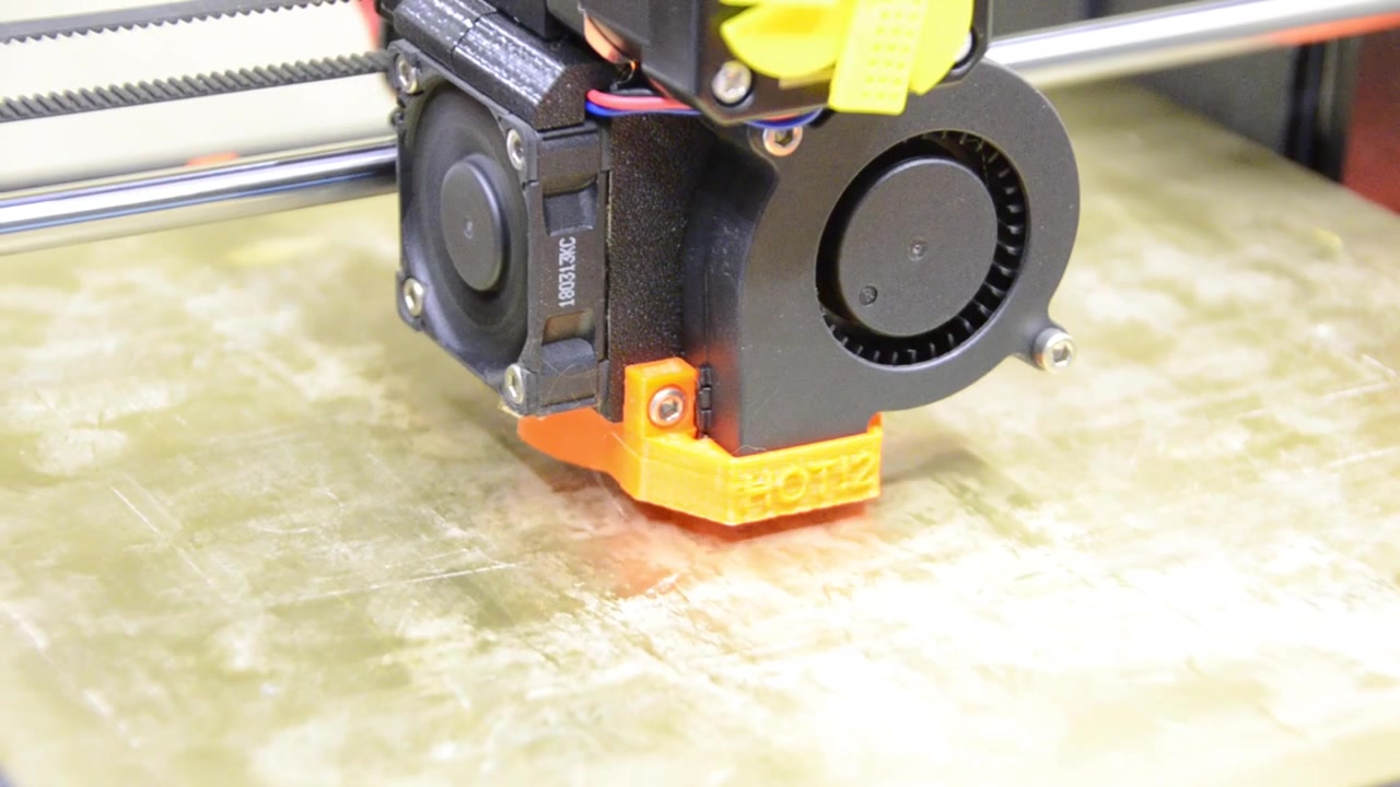 3D printer printing an items that shows the print bed and head moving
