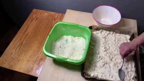 carefully spreading tasty homemade apple tart on oven pan