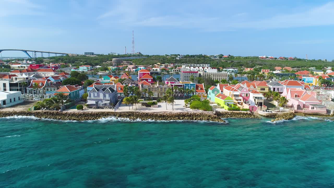Pietermaai and Punda neighborhoods with Juliana Bridge behind, blue ocean water and waves crashing