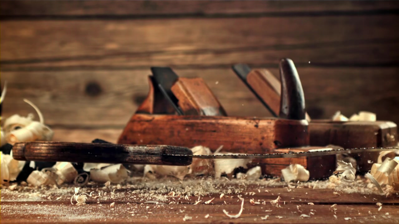 Vintage Hand Saw Falling in Slow Motion on a Carpenter's Workbench