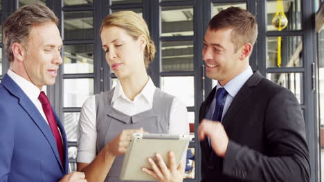 business people talking together while looking tablet