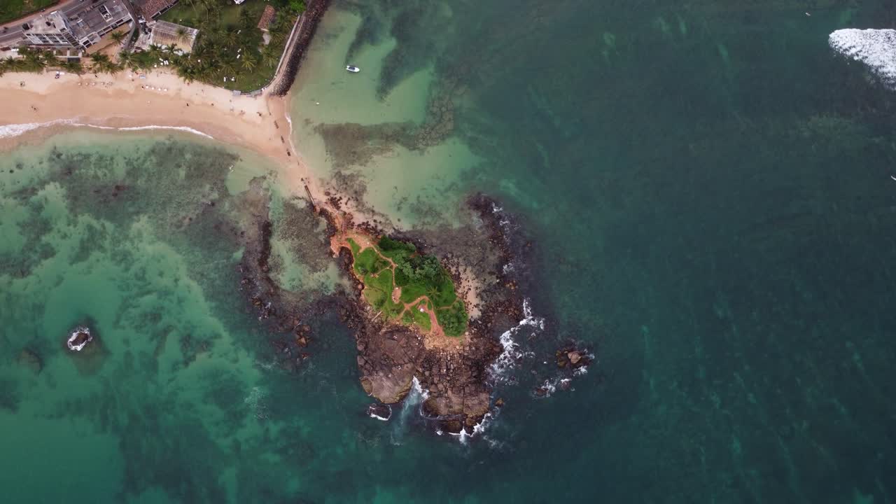 antena de arriba hacia abajo sobre la costa rocosa de la isla de las palomas, playa de arena y mar turquesa durante el día, sri lanka