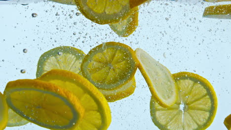 cut lemon floating water close up. tasty vitamin citrus dropped into liquid.