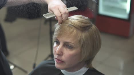 junge frau, die ihre haare im friseursalon anzieht. friseur-stylist bei der arbeit. friseur, der ihre haare nass macht.