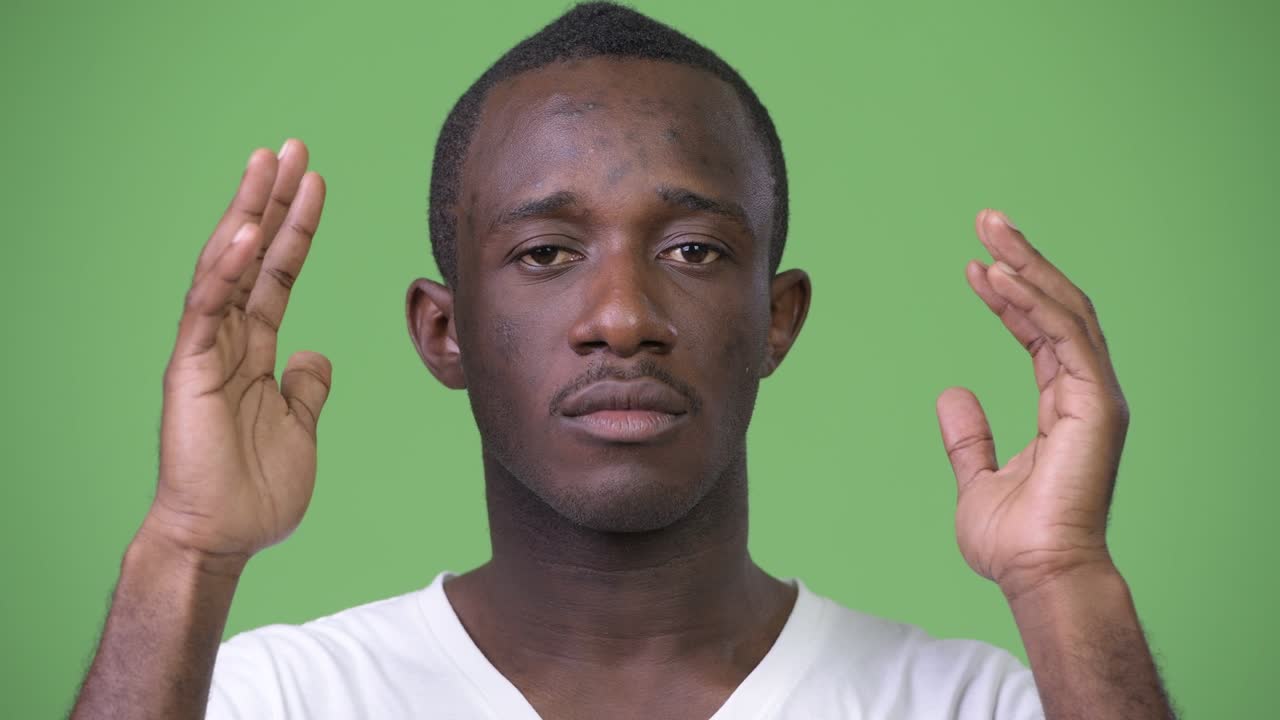 Ung afrikansk mann dekker ørene som de tre vise apene
