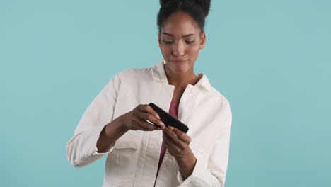 Smiling woman playing videogame on smartphone