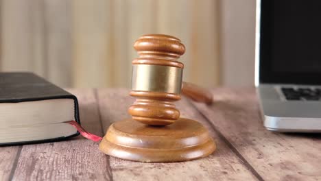 wooden gavel, book, and laptop on table