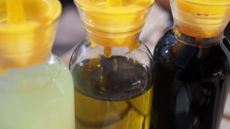 three bottles of oil and vinegar on a table