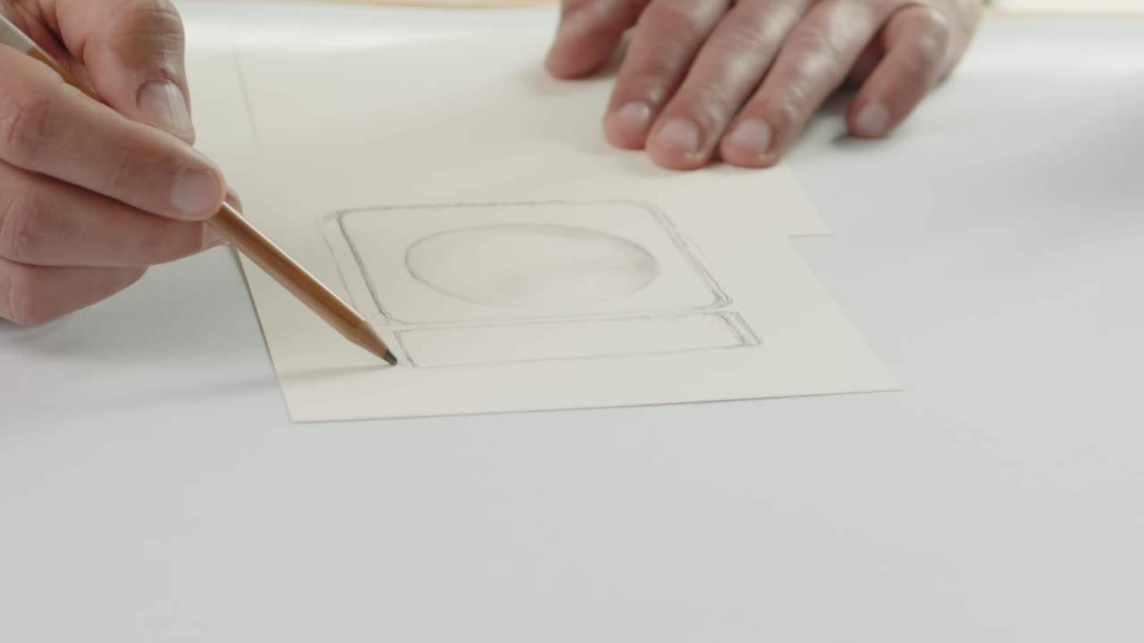 el diseñador dibuja un boceto de un frasco de perfume con un lápiz: el proceso de diseño del embalaje