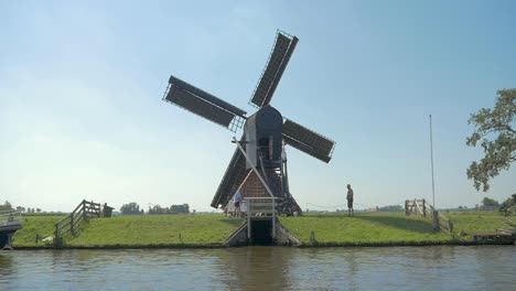 Dutch-Old-Windmill-on-a-dike-near-the-water,-a-small-Dolly-shot-in-slowmotion