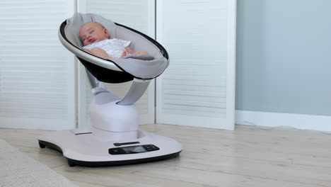 sweet newborn baby girl sleeping in a bouncer chair in a white room