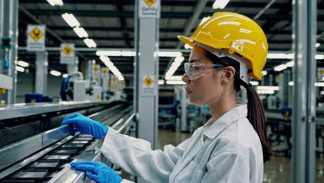 woman factory worker inspecting components on a production line