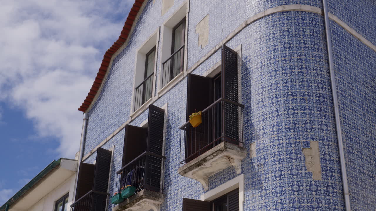 Traditional Portuguese Building Exterior With Blue Azulejo Tiles, Black Shutters And Balconies In Aveiro, Portugal. low angle, static shot