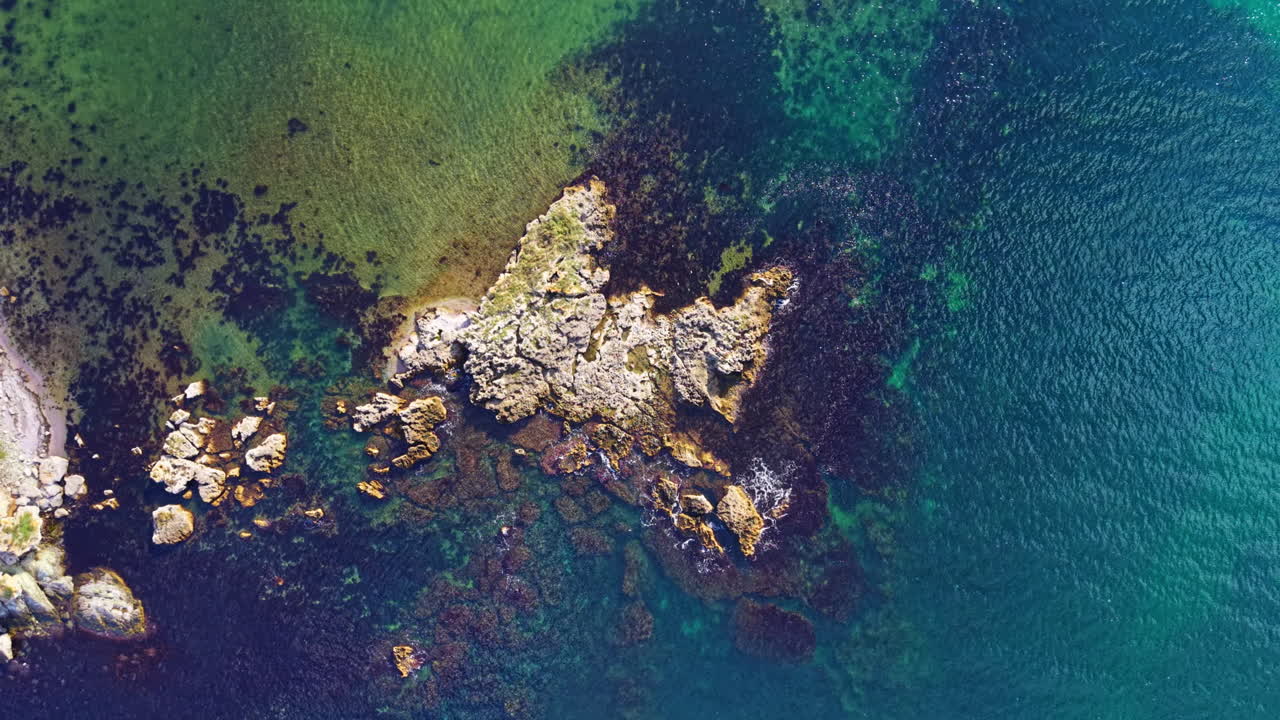 Majestic aerial view revealing vibrant waters and rocky shores of a secluded coastal paradise