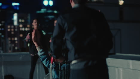 young-group-of-friends-racing-shopping-cart-having-fun-on-rooftop-at-night-enjoying-weekend-celebration-party