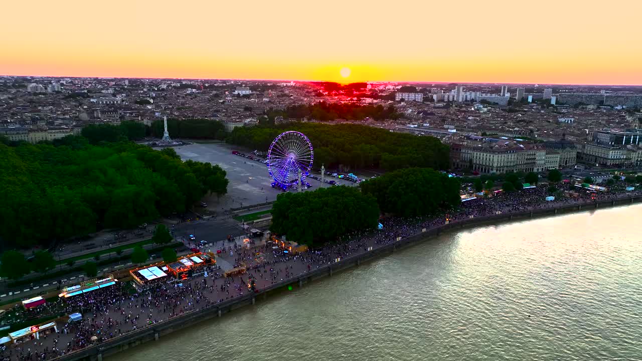 프랑스 보르도 (bordeaux) 의 place des quinconces에 있는 페리스  (ferris wheel) 은 일몰 중에 회전하고 네온으로 조명된다.