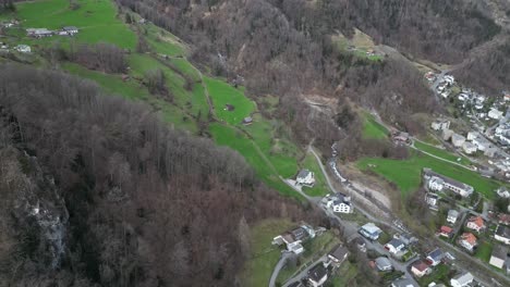 bird's eye overview above european homes on grassy sloping hillsides in walensee switzerland