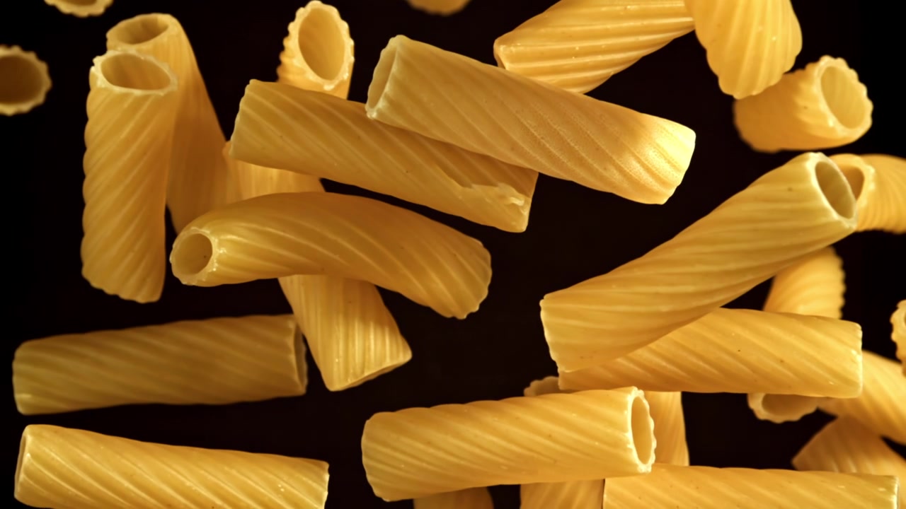 Pasta secca che cade al rallentatore su sfondo nero