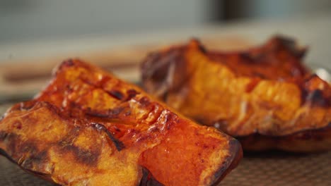 Panning-up-shot-of-roasted-pumpkin-fresh-out-the-oven-charred-grilled-gourd