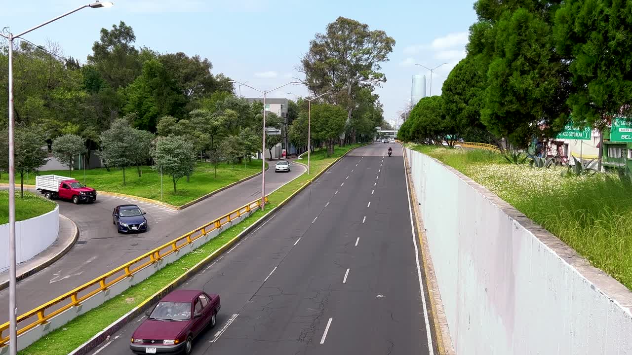 lapso de tiempo de la avenida churubusco en la ciudad de méxico, que muestra un gran edificio en el fondo
