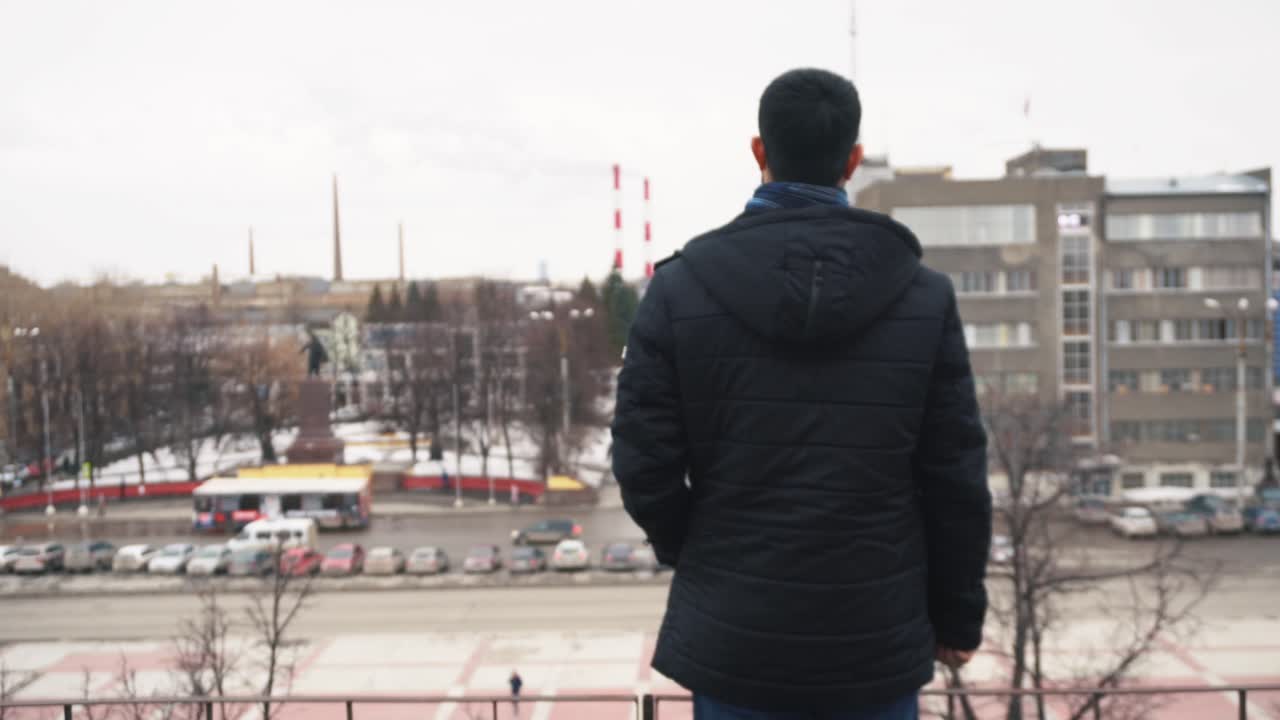 추운 날 도시 풍경을 바라보는 남자