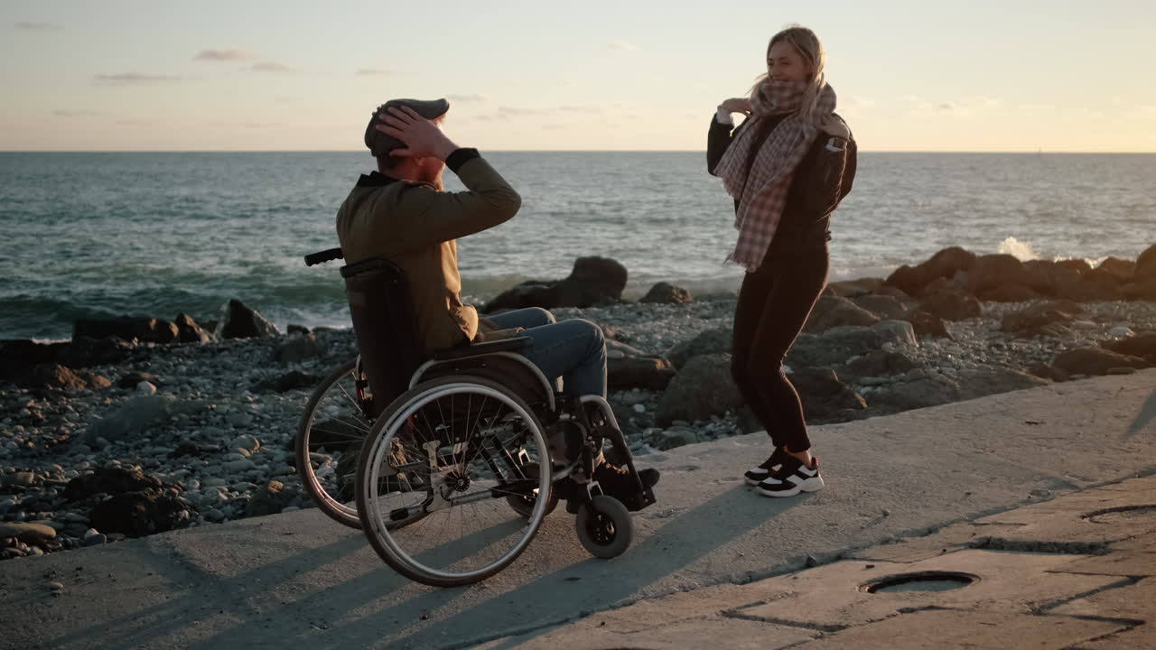 pareja discapacitada bailando en la playa al atardecer