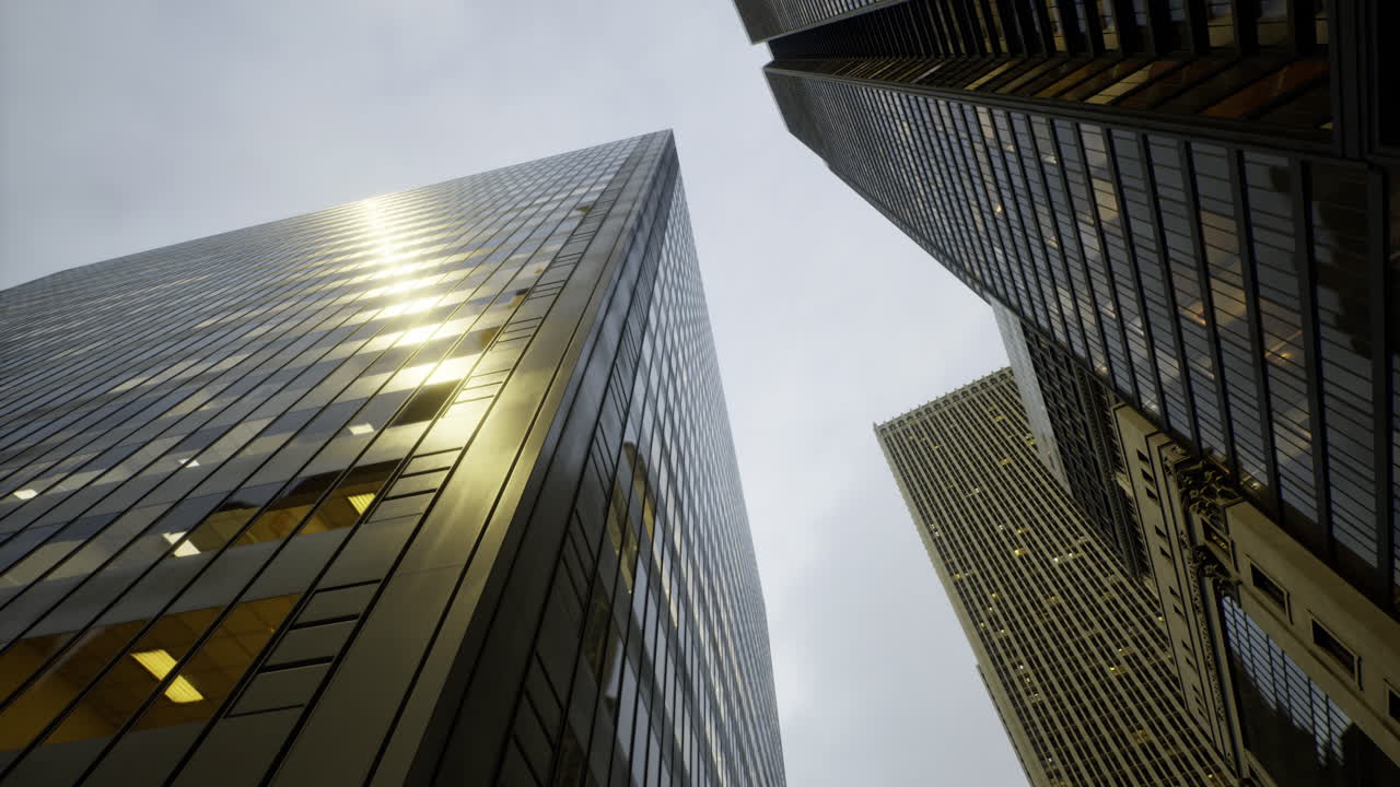 Tall buildings reflect light under a cloudy sky in an urban setting