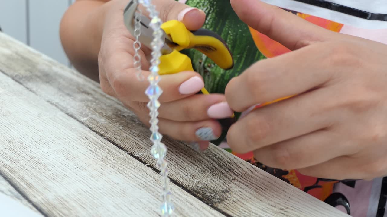 vista cercana de manos femeninas reparando una pulsera de cristal-1