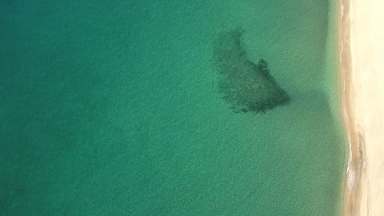 High Aerial Drone Fly Over Footage of green emerald ocean beach at Cabo San Lucas, Mexico