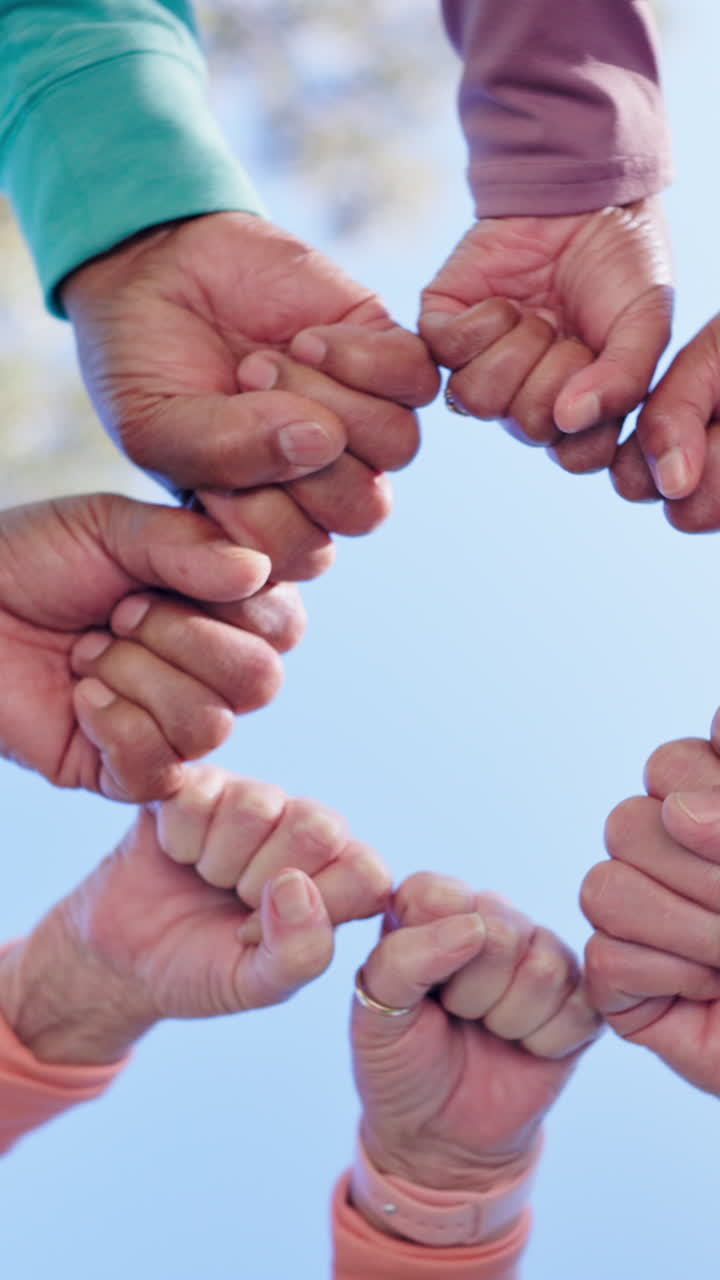 Diverse Hands Holding Together in a Circle Against the Sky