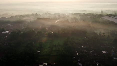 cinematic aerial view of village at the base of mount argopuro at sunrise