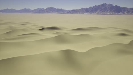 vast desert landscape with gentle sand dunes and distant mountains