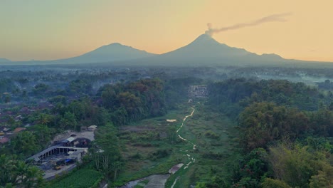 impresionante vista en la hora dorada sobre la cascada de watu purbo y el volcán merapi, indonesia