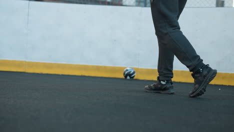 back view of athlete jogging on sport arena with focus on legs and shoes, showcasing dynamic movement, fitness, and agility against yellow boundary and urban background