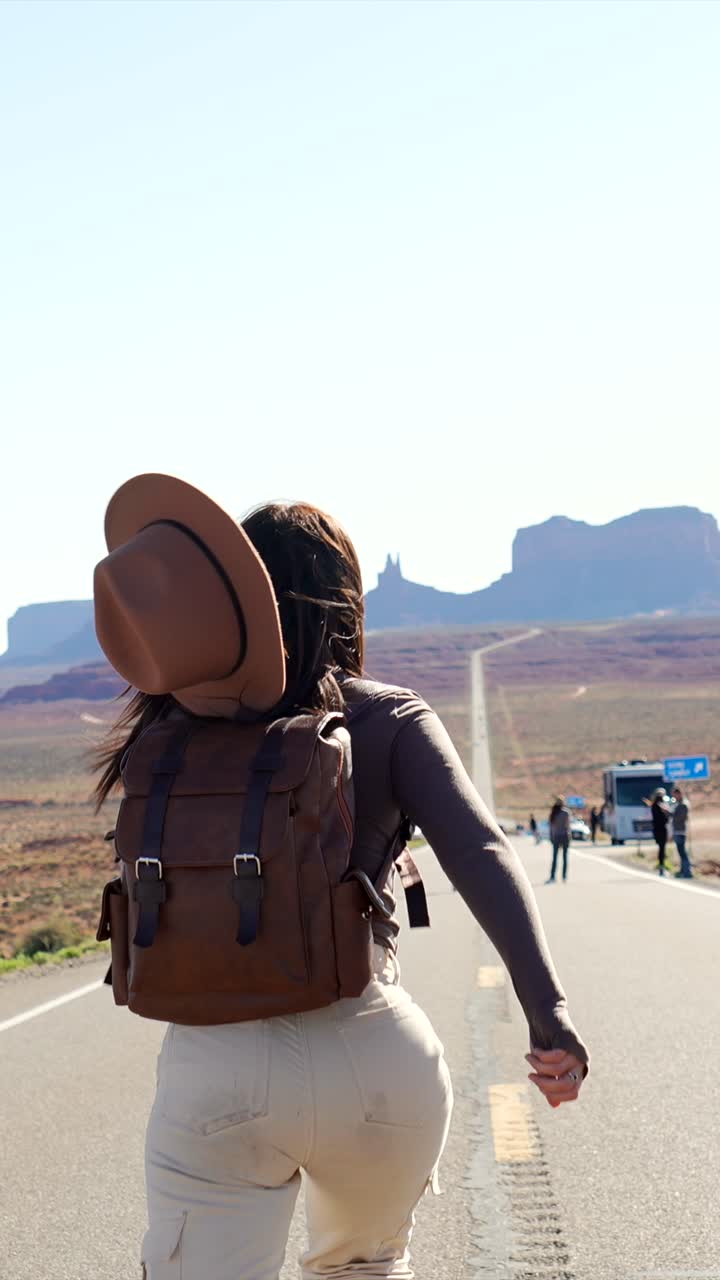 Giovane donna che corre su una strada desertica nella Monument Valley
