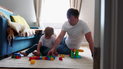 happy family dad mom and baby 2 years playing lego in their bright living room. slow-motion shooting happy family