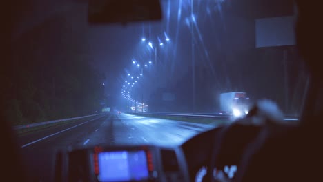 the man driving on a wet night road