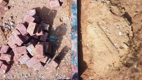 building a house with red stone , works using cement ,construction using earthen blocks, building the foundation of the house, workers work at a construction site in india