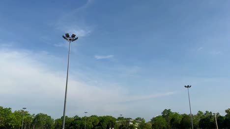 Pocos-Focos-LED-Durante-El-Día-Con-Cielo-Azul-Y-árboles-Verdes.