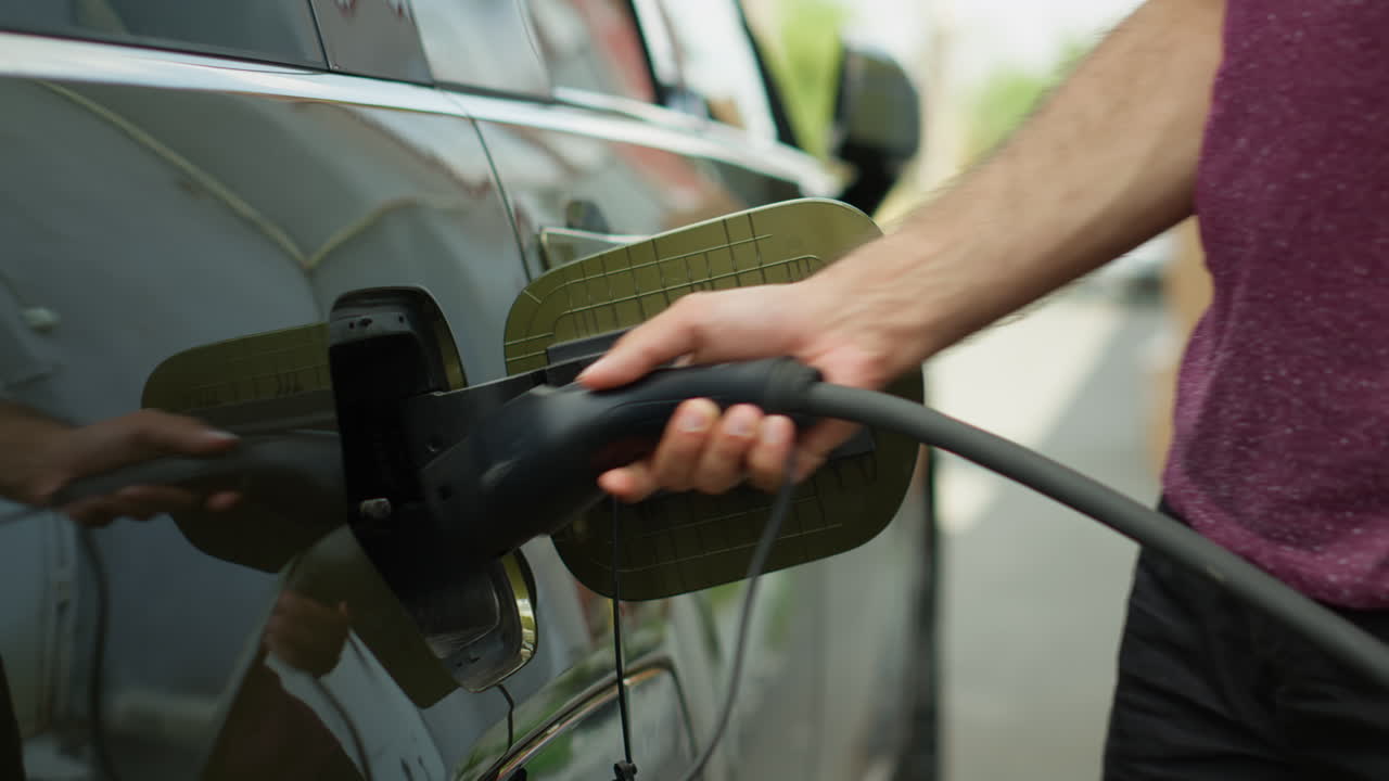 Close Up Of Person Opening Vehicle Inlet Port To Charge Electric Automobile