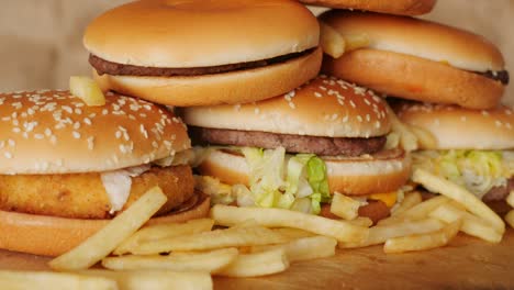 porción de comida no saludable, comida rápida, pila de hamburguesas, patatas fritas girando, girando