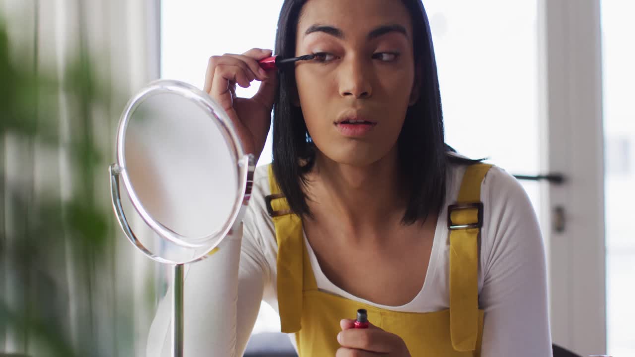 vlogger de género fluido de raza mixta grabando un vlog de maquillaje en casa