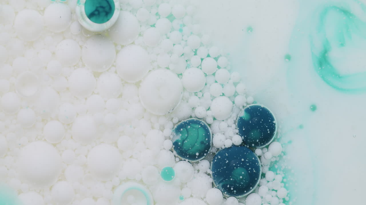 burbujas azules y blancas flotando en líquido transparente