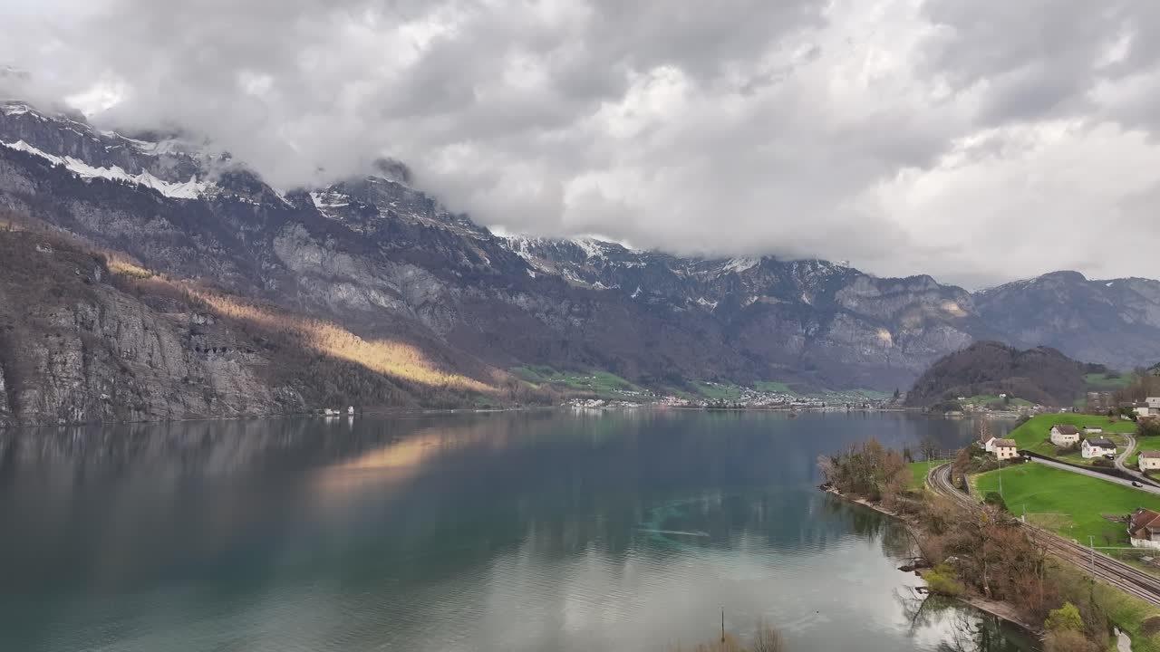 lago walensee al pie de las cimas nevadas de las montañas churfirsten